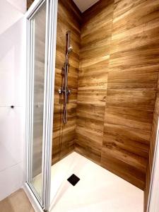 ducha con paredes de madera y puerta de cristal en Ground floor with garden, swimming pool and private parking, en Sóller