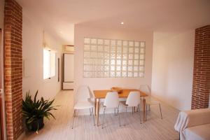 a dining room with a table and white chairs at Ground floor with garden, swimming pool and private parking in Sóller