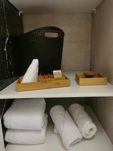un estante con toallas y una caja de toallas en CrackedBrick Warsaw Rentals en Varsovia