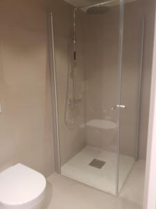 een badkamer met een douche en een toilet bij Ny leilighet i Tromsøs nye bydel in Tromsø