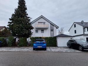 een blauwe auto geparkeerd voor een huis bij Schöni´s Zimmer in Abstatt