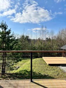 a balcony with a view of a park with trees at Budzi nas las 