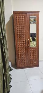 a wooden cabinet with a mirror in a room at Fully Furnished Studio Appartment next to Sharaf DG metro Station in Dubai