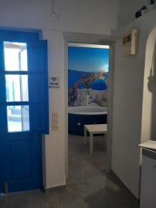 una camera con porta blu e un letto con vista di VI STA FINIKIAS VILLA a Oia