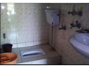 a small bathroom with a toilet and a sink at Hotel Chandradeep, Joshimath in Joshīmath