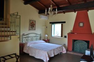 a bedroom with a bed and a fireplace at Le Macchie in Calopezzati +10 photos