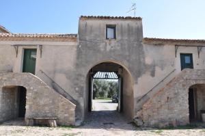 una entrada a un antiguo edificio de piedra con un arco en Le Macchie, en Calopezzati