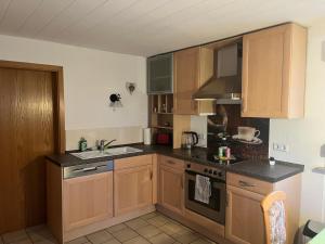 a kitchen with wooden cabinets and a sink at Jenny‘s FeWo in Idar-Oberstein