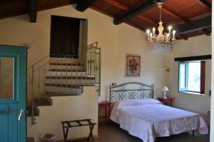 a bedroom with a bed and a staircase and a chandelier at Le Macchie in Calopezzati
