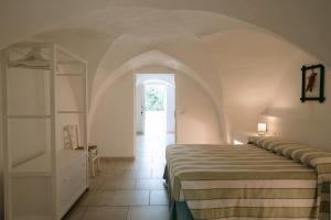 a bedroom with a bed and a shelf in a room at Oltre gli Ulivi in Ostuni +59 photos