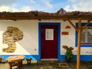 una casa azul y blanca con una puerta roja en HERDADE VALE DE GAIOS by Stay in Alentejo en São Luis