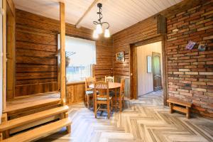 a dining room with a table and a brick wall at Cidoniju māja in Kubuļi