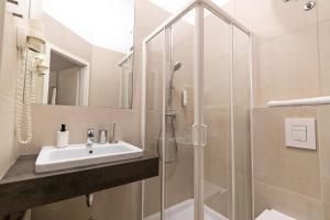 La salle de bains est pourvue d'un lavabo et d'une douche. dans l'établissement Galeria Rooms, à Ljubljana