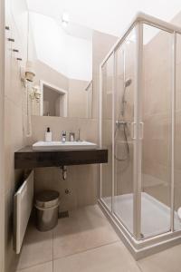 La salle de bains est pourvue d'un lavabo et d'une douche. dans l'établissement Galeria Rooms, à Ljubljana