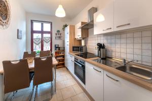 a kitchen with a sink and a table with chairs at Naumburger Charme St. Barbara in Naumburg