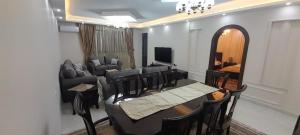 a dining room with a table and chairs and a couch at Luxury Apartment 3BR near 7th circle in Amman