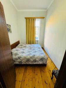 Schlafzimmer mit einem Bett und einem Fenster in der Unterkunft GUEST HOUSE "BUBU" in Kutaissi