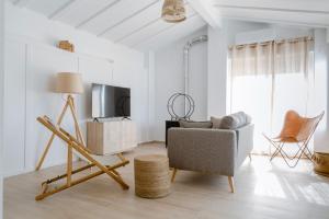 a living room with a tv and a chair at Finca de L’ANGLÉS Casa Poniente in Potríes