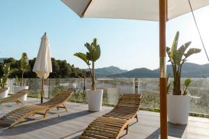 a group of chairs and an umbrella on a patio at Finca de L’ANGLÉS Casa Poniente in Potríes