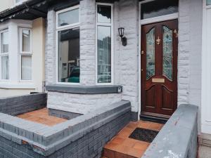 una casa con una porta marrone e una finestra di Pass the Keys Tranquil Green Retreat - 3 Bed Tuebrook Terrace a Liverpool