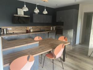 eine Küche mit einem Holztisch und orangefarbenen Stühlen in der Unterkunft Appartement cosy au calme in Chindrieux