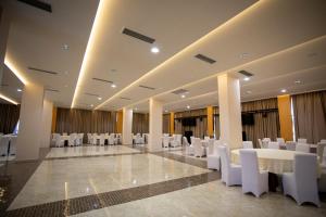 a banquet hall with white tables and white chairs at Resort Zdrava in Savër