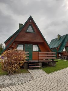 ein großes Holzhaus mit grüner Tür in der Unterkunft Domki całoroczne u Eli in Szczyrk