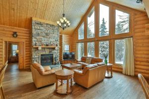 a living room with a couch and a fireplace at Chalet Authentik 27 - Hot tub, Pools, Lake & Resort in Mille-Isles