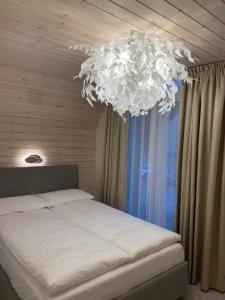 ein Schlafzimmer mit einem Bett mit einem großen Kronleuchter in der Unterkunft Geriausios Atostogos in Palanga