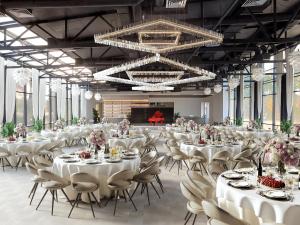 a large banquet hall with white tables and chairs at Koncha Zaspa Park by HeyDay in Kozin