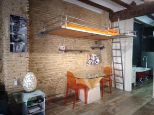 een kamer met een tafel en een hoogslaper bij Valencia Centro Suite in Valencia