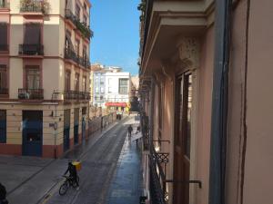 een persoon die fietst op een straat naast een gebouw bij Valencia Centro Suite in Valencia
