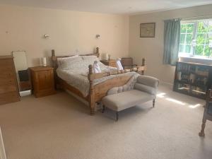 um quarto com uma cama e uma cadeira em Relaxing country cottage bungalow em Yaxley