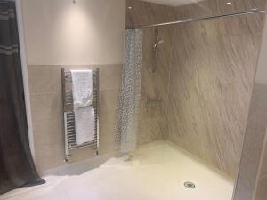 uma casa de banho com chuveiro e cortina de chuveiro em Relaxing country cottage bungalow em Yaxley