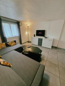 a living room with two beds and a flat screen tv at Appartement Cosy - Proche Dysneyland - Paris - RER in Noisy-le-Grand