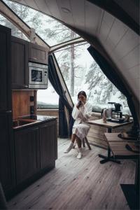 a woman sitting at a table in a kitchen at Syöte Igloos in Syöte