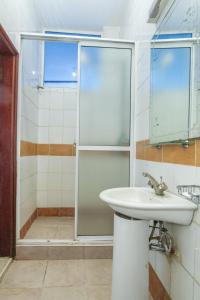 La salle de bains est pourvue d'un lavabo et d'une douche. dans l'établissement Fahari Bliss Hotel, à Nairobi