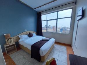 a bedroom with a bed and a large window at Fahari Bliss Hotel in Nairobi