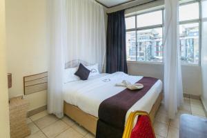 sypialnia z dużym łóżkiem i oknem w obiekcie Fahari Bliss Hotel w mieście Nairobi
