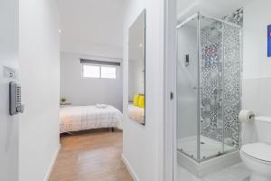 a bathroom with a shower with a toilet and a bed at LooP America in Madrid