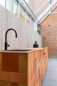 a kitchen with a sink and a brick wall at stek&stoof in Sint-Pauwels