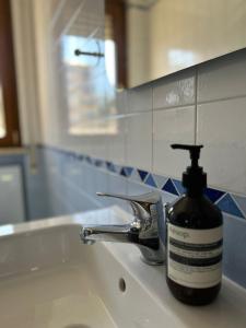 a bottle of soap sitting on a bathroom sink at The Attic Apartment in Rome