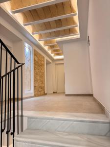 Habitación vacía con techos de madera y escalera. en Casa Boutique Navarro, en Montilla