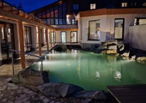 una piscina de agua verde frente a un edificio en Hotel Horal, en Rožnov pod Radhoštěm