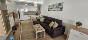 a living room with a couch and a kitchen at Villa Solycan 15 in Playa del Ingles