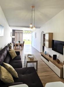a living room with a couch and a tv at Villa Solycan 15 in Playa del Ingles