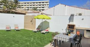 a patio with a table and chairs and an umbrella at Villa Solycan 15 in Playa del Ingles