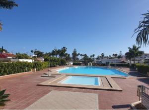 a large swimming pool on a brick walkway next to a resort at Villa Solycan 15 in Playa del Ingles