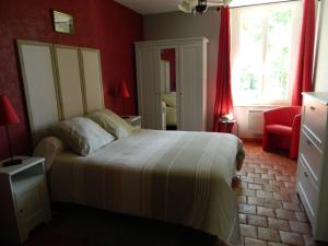 - une chambre avec un lit et un mur rouge dans l'établissement Meublés de tourisme La Reserve, à Saint-Pierre-les-Bois