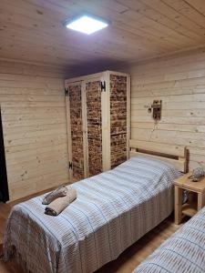 1 dormitorio con 1 cama en una habitación de madera en Cabana Alpha, en Baia Mare